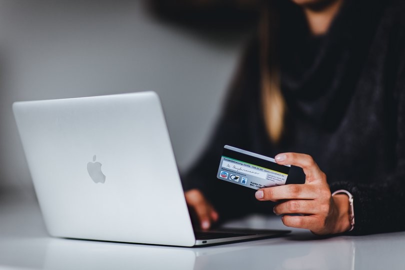 Eine Person, die eine Kreditkarte für einen Online-Einkauf verwendet